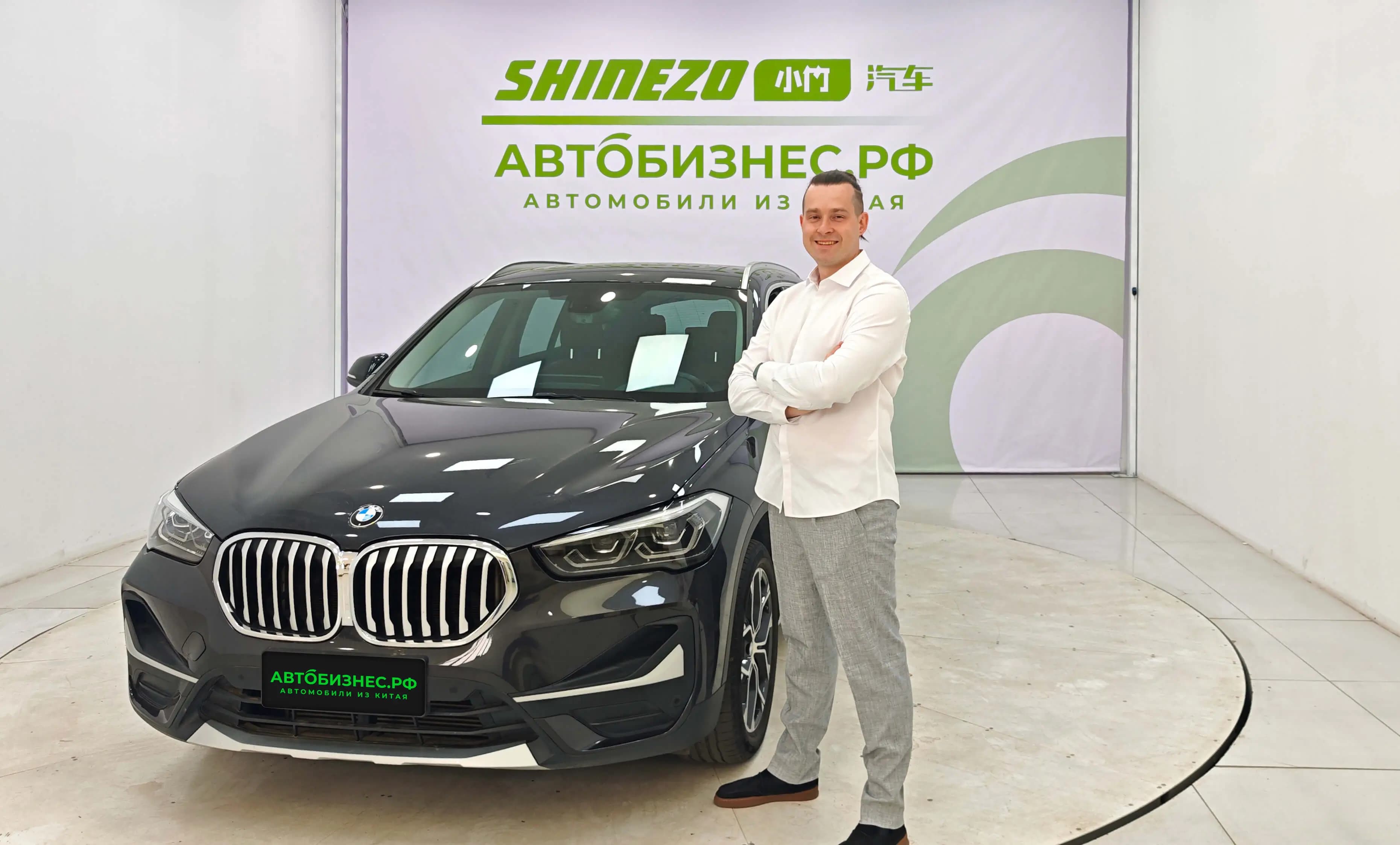 Стас Богословский на фоне баннера Shinezo с автомобилем BMW